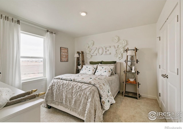 bedroom with light carpet and a closet