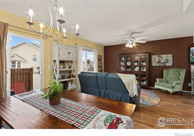 dining area featuring hardwood / wood-style floors and ceiling fan with notable chandelier