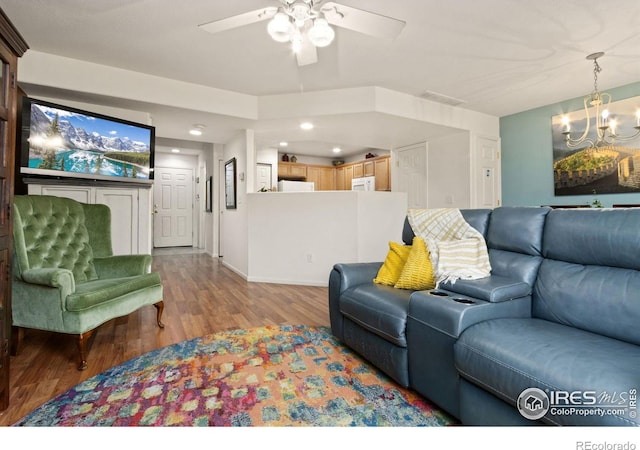 living room with ceiling fan with notable chandelier and light wood-type flooring