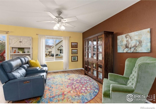 living room featuring hardwood / wood-style floors and ceiling fan