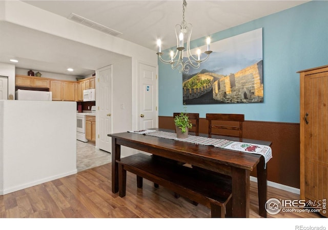 dining space featuring a chandelier and light hardwood / wood-style floors