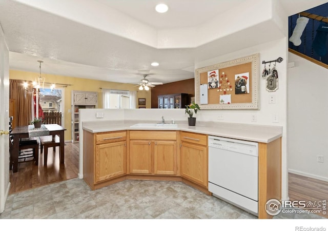 kitchen with kitchen peninsula, ceiling fan with notable chandelier, pendant lighting, dishwasher, and light hardwood / wood-style floors