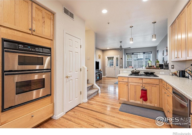 kitchen featuring light brown cabinetry, light hardwood / wood-style flooring, pendant lighting, and appliances with stainless steel finishes