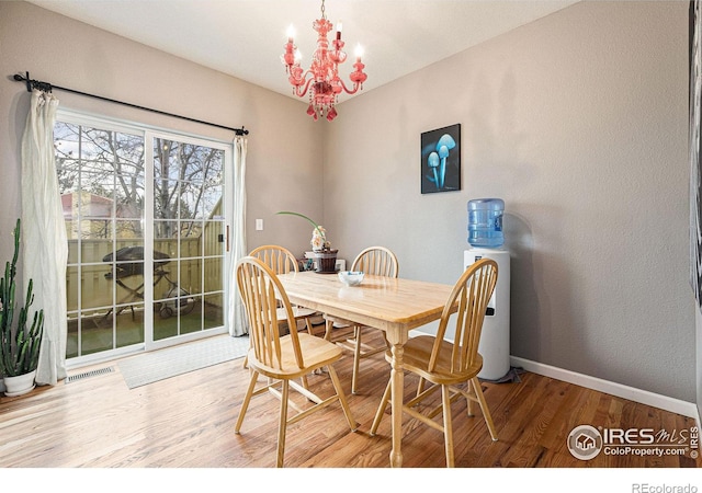 dining room with hardwood / wood-style flooring and a notable chandelier