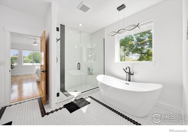 bathroom featuring ceiling fan, shower with separate bathtub, and hardwood / wood-style flooring