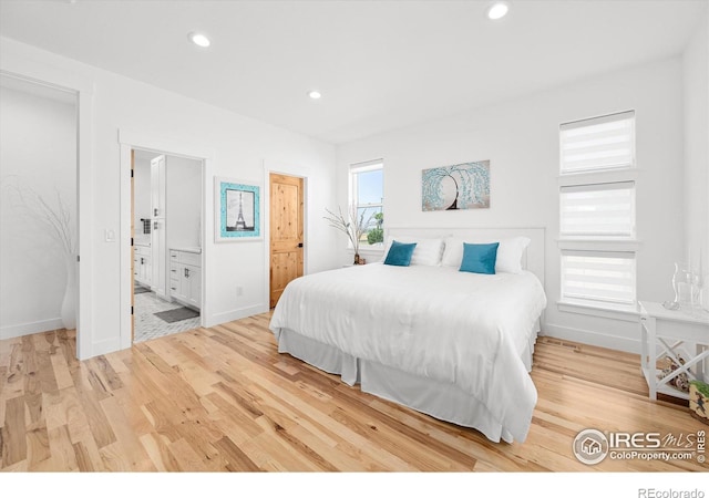 bedroom with light wood-type flooring and ensuite bath