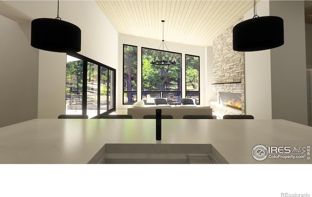 unfurnished dining area featuring a stone fireplace, wooden ceiling, vaulted ceiling, and a notable chandelier