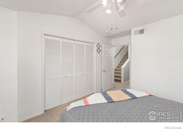 bedroom featuring ceiling fan, light colored carpet, lofted ceiling, and a closet