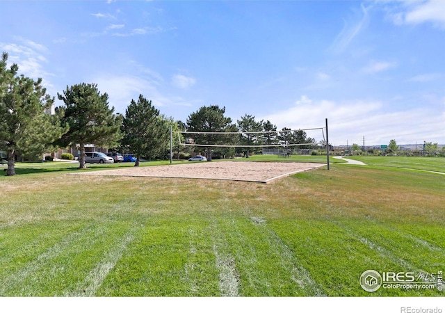 view of property's community with a lawn and volleyball court