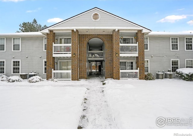 snow covered property with central AC