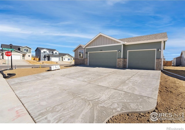 view of front of home featuring board and batten siding, a residential view, driveway, and a garage