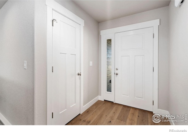 entryway with light wood finished floors and baseboards