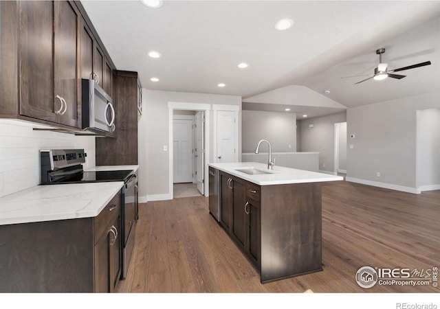 kitchen with appliances with stainless steel finishes, dark brown cabinets, and a sink