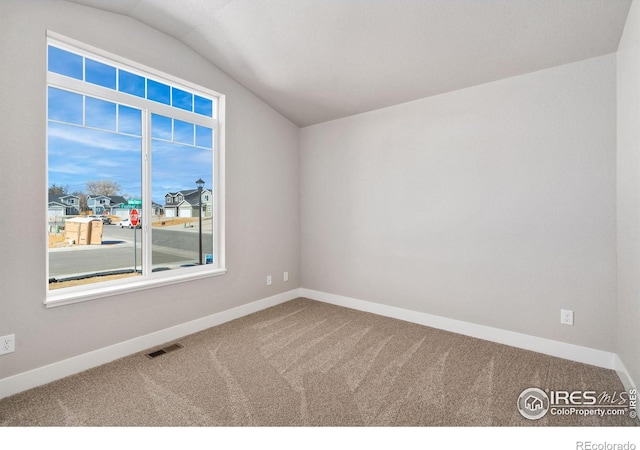 interior space with vaulted ceiling, carpet floors, visible vents, and baseboards