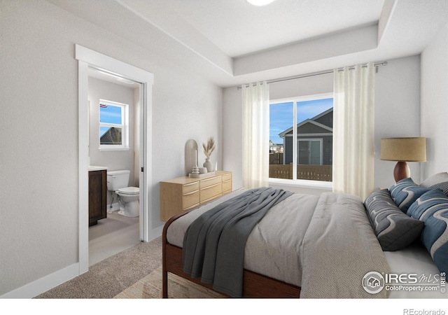 bedroom featuring light carpet, ensuite bath, multiple windows, and baseboards