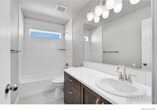 full bath with a textured ceiling, tile patterned flooring, toilet, vanity, and visible vents