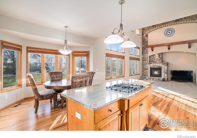 kitchen with a fireplace, light hardwood / wood-style flooring, and decorative light fixtures