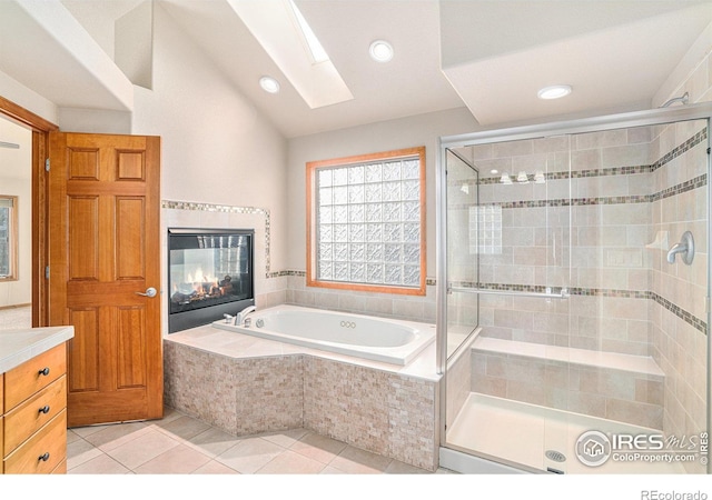 bathroom featuring lofted ceiling with skylight, tile patterned flooring, and shower with separate bathtub