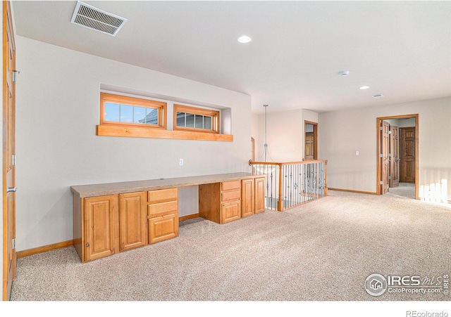 unfurnished office featuring light carpet and built in desk