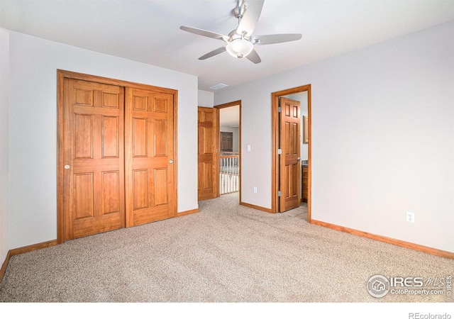 unfurnished bedroom with ceiling fan, light carpet, and a closet