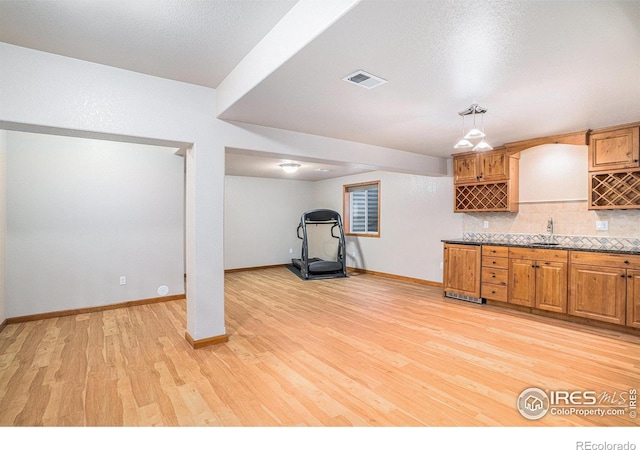 interior space featuring sink, a textured ceiling, and light hardwood / wood-style flooring