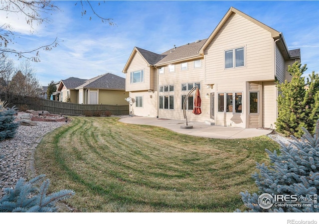 rear view of property featuring a yard and a patio