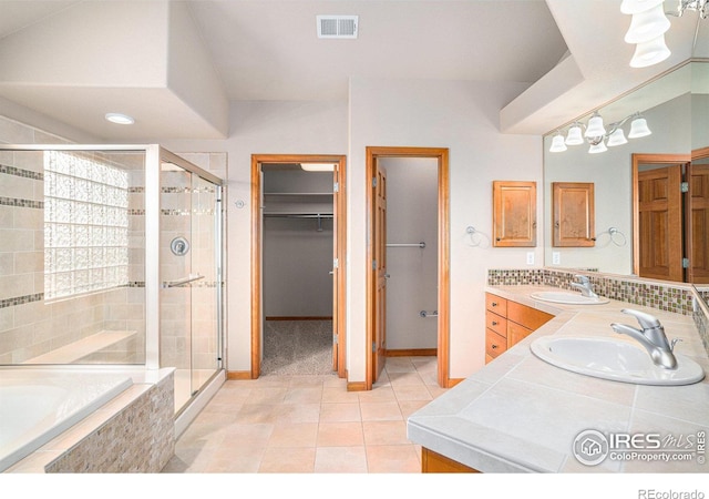 bathroom with tile patterned flooring, vanity, separate shower and tub, and a chandelier