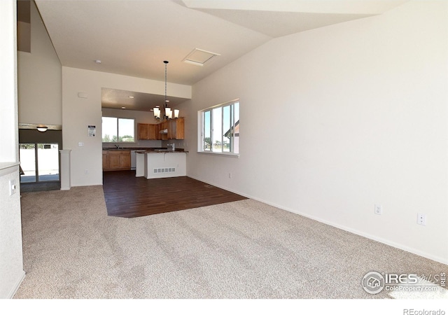 unfurnished living room with lofted ceiling, carpet floors, and an inviting chandelier