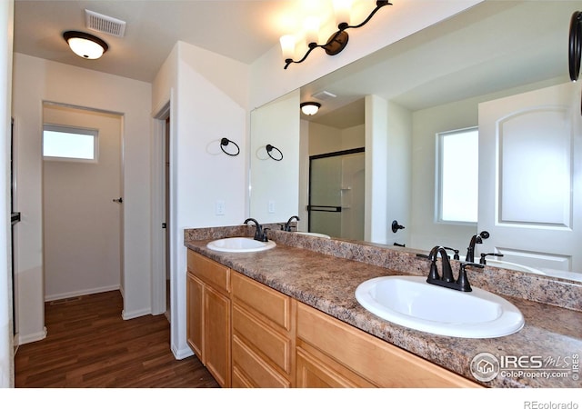 bathroom featuring plenty of natural light, wood-type flooring, walk in shower, and vanity
