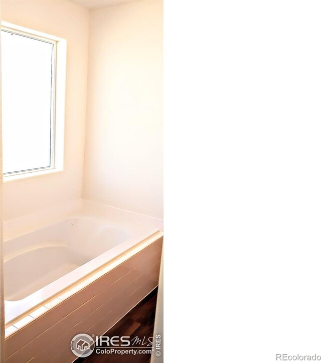 bathroom with a relaxing tiled tub