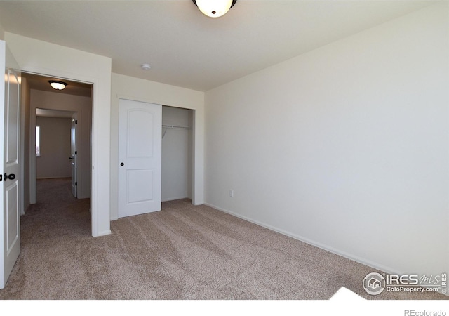 unfurnished bedroom featuring a closet and light colored carpet