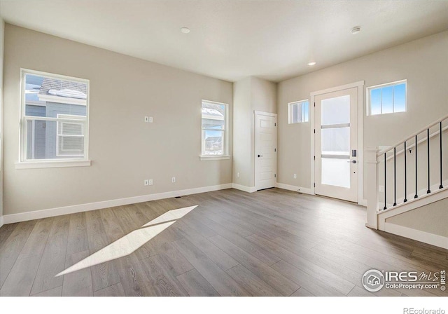 foyer entrance with light hardwood / wood-style flooring and a healthy amount of sunlight