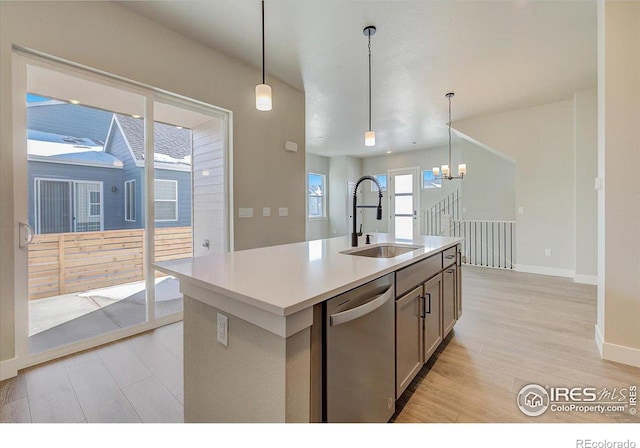 kitchen with dishwasher, an island with sink, plenty of natural light, and sink