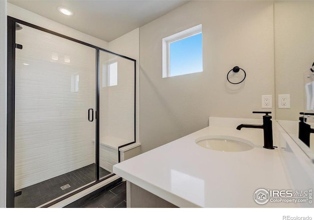 bathroom with vanity and a shower with shower door