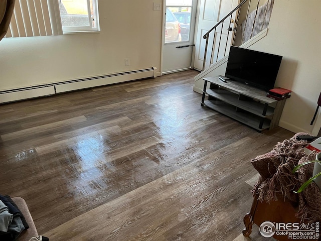 living room featuring a baseboard heating unit and dark wood-type flooring