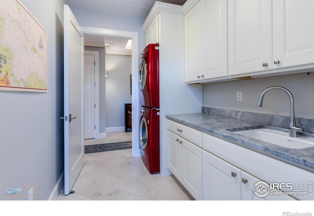 1077 Canyon Blvd # 403, Boulder, CO 80302 - laundry room with cabinet space, stacked washer and clothes dryer, light tile patterned floors, and baseboards