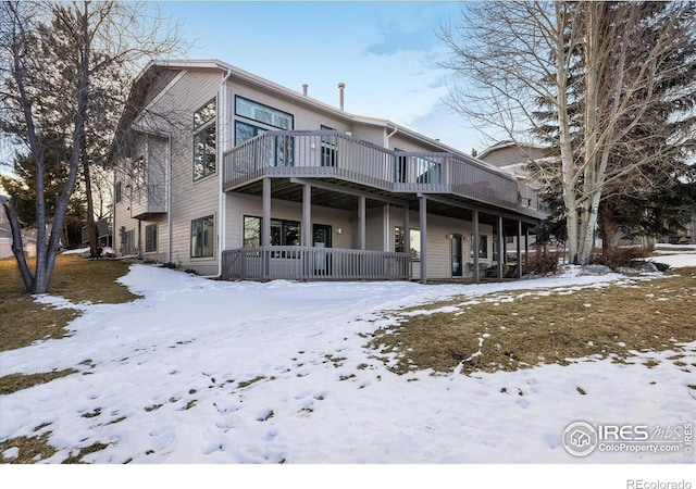 snow covered property with a wooden deck