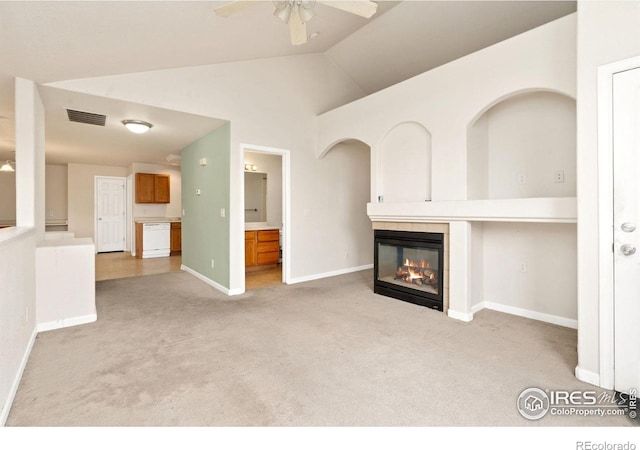 unfurnished living room with ceiling fan, lofted ceiling, and light carpet