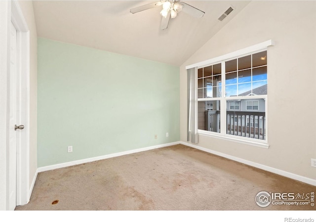 carpeted spare room with ceiling fan and vaulted ceiling