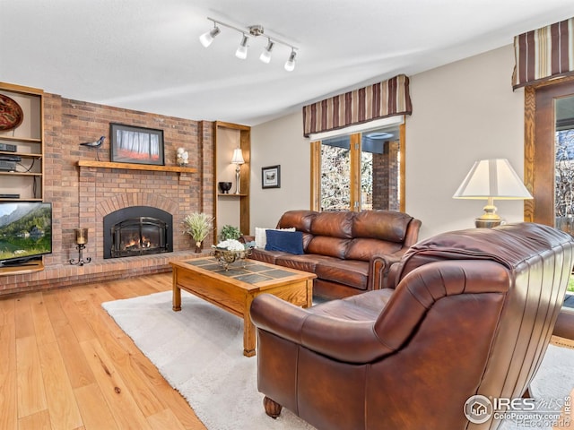 living room with hardwood / wood-style flooring and a brick fireplace