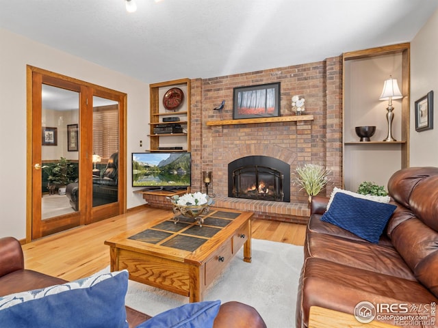 living room featuring hardwood / wood-style floors and a brick fireplace