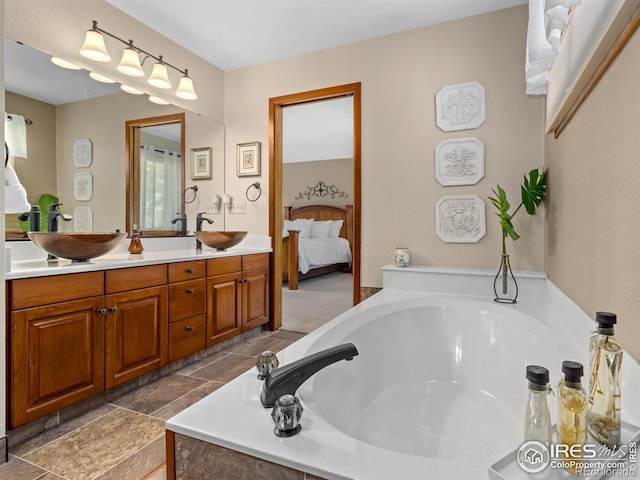 bathroom featuring tiled bath and vanity