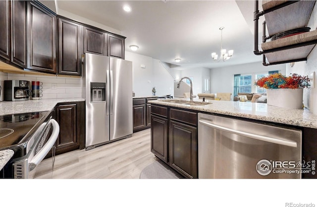 kitchen with appliances with stainless steel finishes, light hardwood / wood-style flooring, dark brown cabinets, and sink