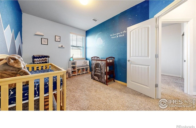 bedroom with carpet and a crib