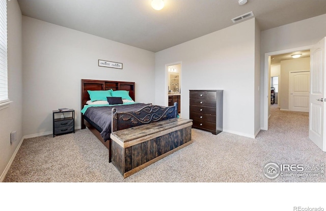 bedroom featuring light carpet and ensuite bath