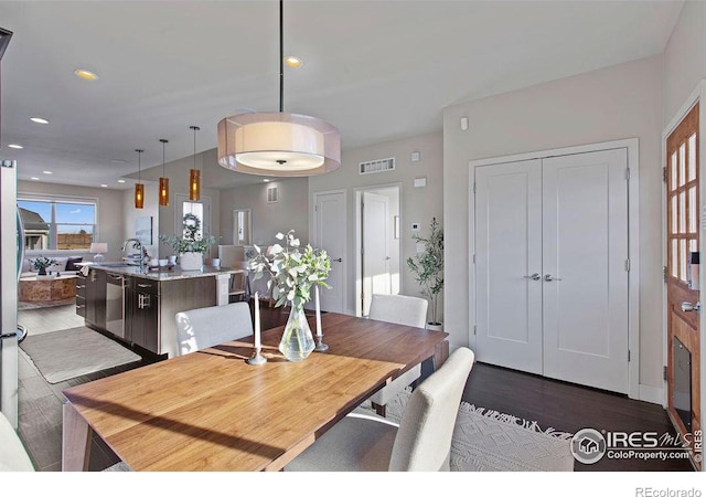 dining area with dark hardwood / wood-style flooring and sink