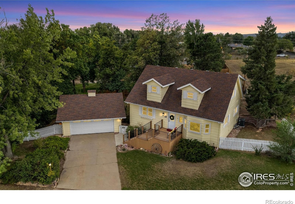 view of front of home featuring central AC, a yard, an outbuilding, and a garage