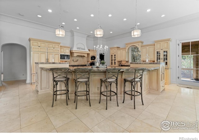 kitchen featuring decorative light fixtures, black microwave, and a spacious island