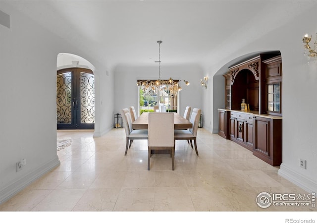 dining area with a notable chandelier and french doors