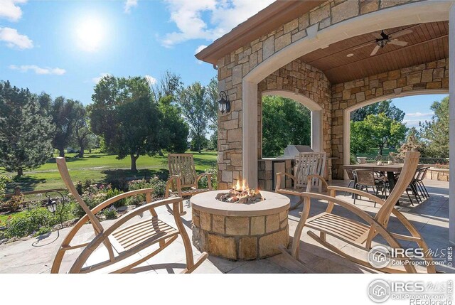 view of patio featuring ceiling fan and an outdoor fire pit